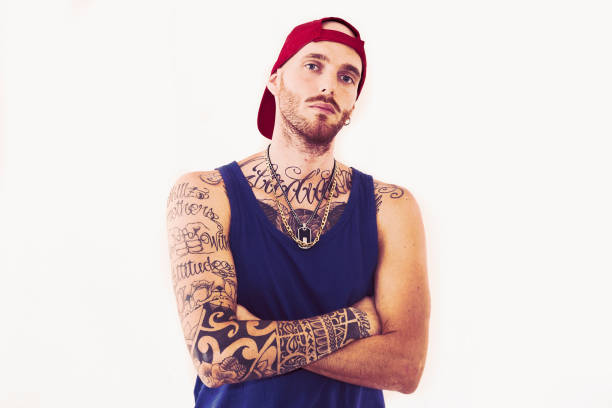 tattooed-rap-singer-posing-in-studio-on-a-white-background-picture-id851501228
